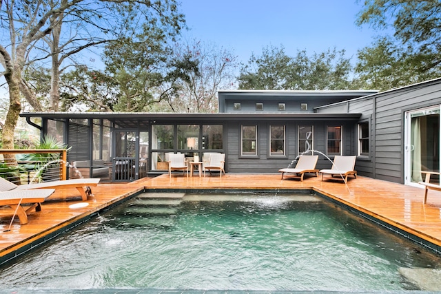 rear view of property featuring a pool side deck and a sunroom