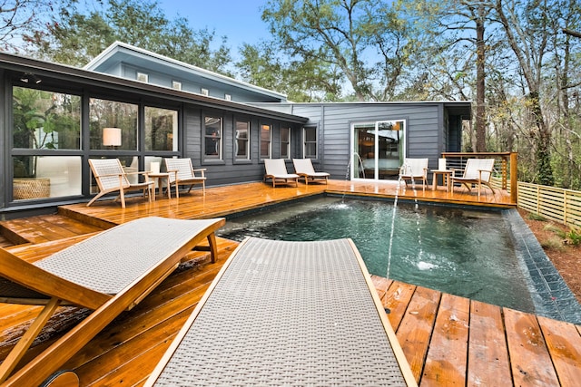 back of property with a wooden deck and pool water feature