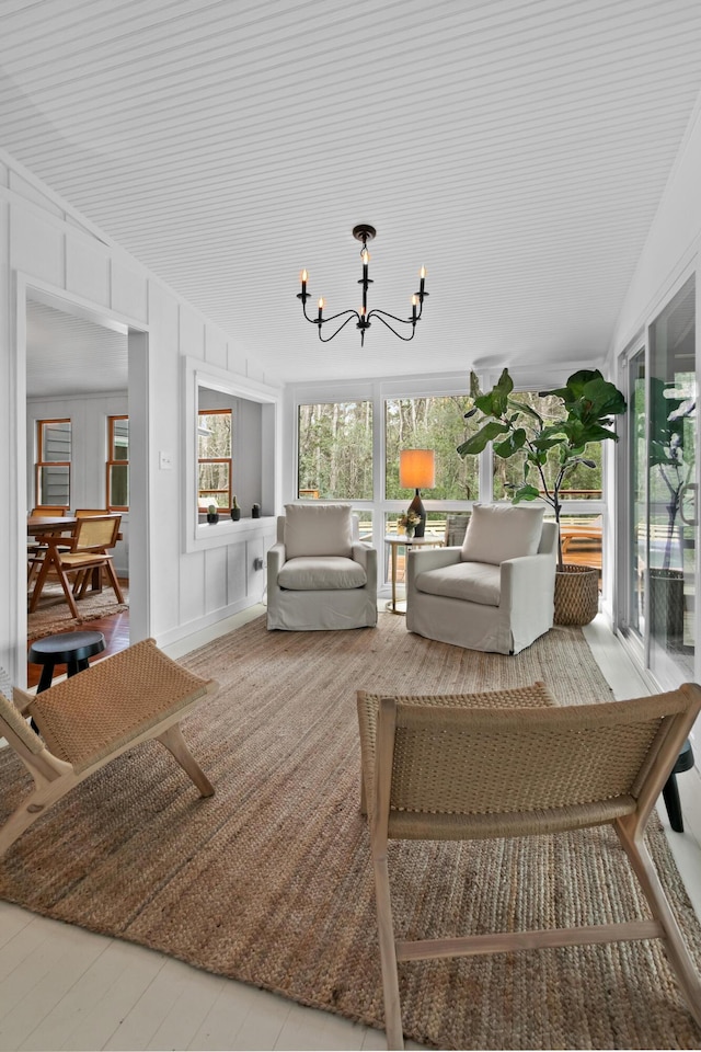 sunroom / solarium featuring a notable chandelier