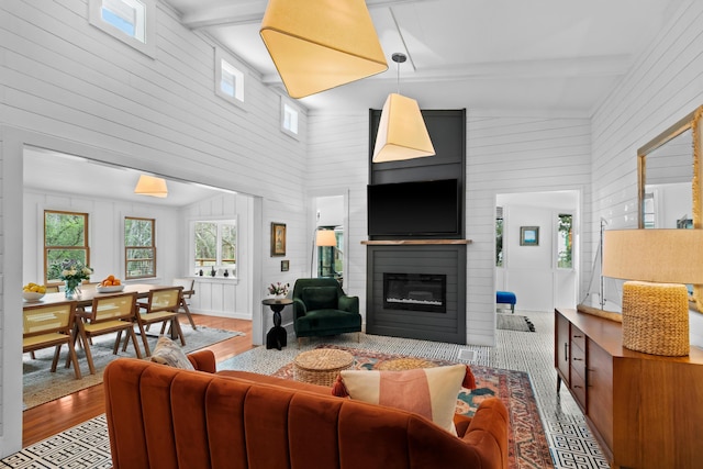 living room featuring a fireplace, light wood-type flooring, high vaulted ceiling, and beamed ceiling