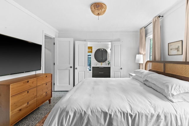 bedroom featuring ensuite bathroom and ornamental molding