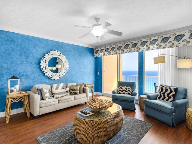 living room with a textured ceiling, ceiling fan, a water view, and dark hardwood / wood-style flooring