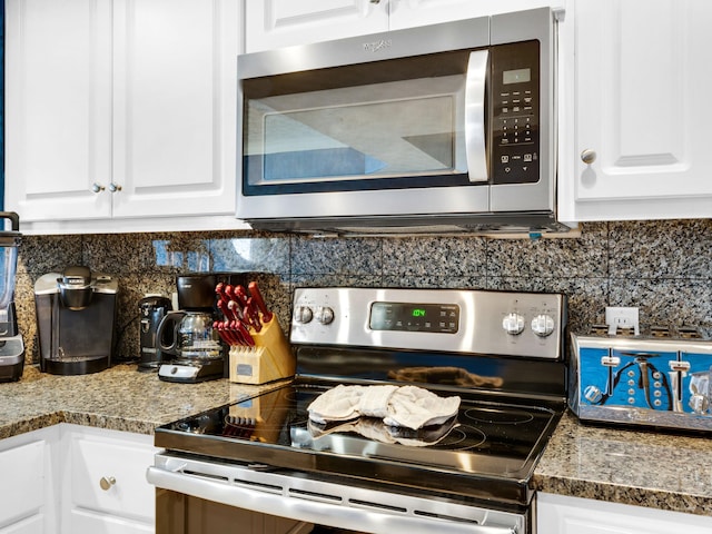 kitchen featuring white cabinets, backsplash, and stainless steel appliances