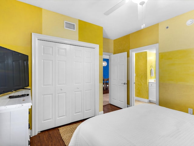 bedroom with ceiling fan, a closet, ensuite bathroom, and dark wood-type flooring