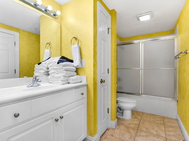 full bathroom with tile flooring, shower / bath combination with glass door, toilet, and vanity