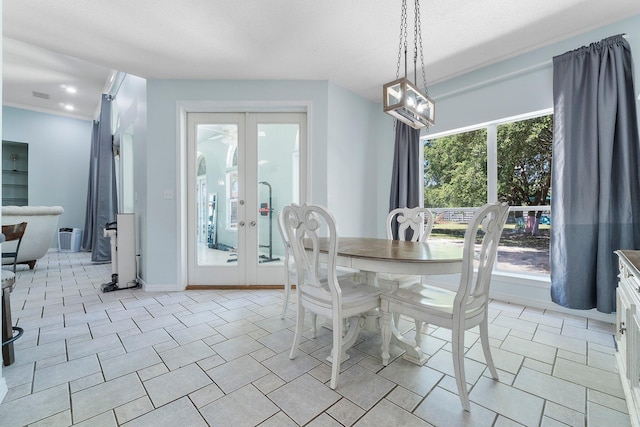 tiled dining space featuring french doors, ornamental molding, and a textured ceiling