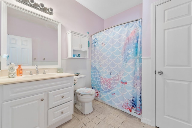 bathroom with tile floors, toilet, and vanity