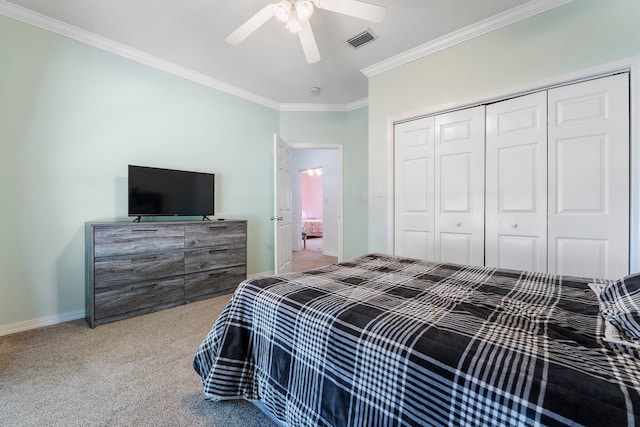 carpeted bedroom featuring crown molding, a closet, and ceiling fan