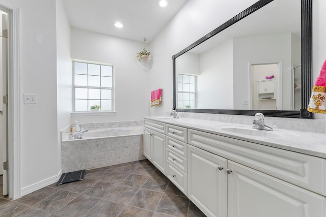 bathroom featuring double vanity, tile flooring, and a bath to relax in