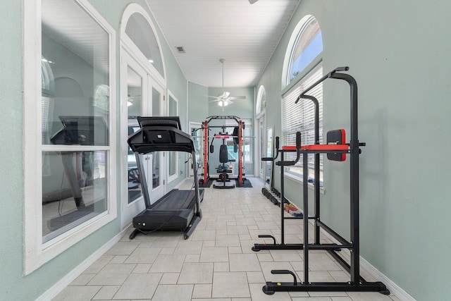 workout room with ceiling fan and light tile floors