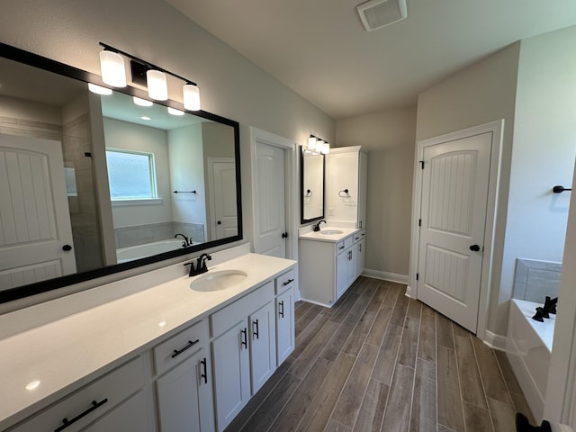 bathroom featuring vanity, hardwood / wood-style flooring, and separate shower and tub