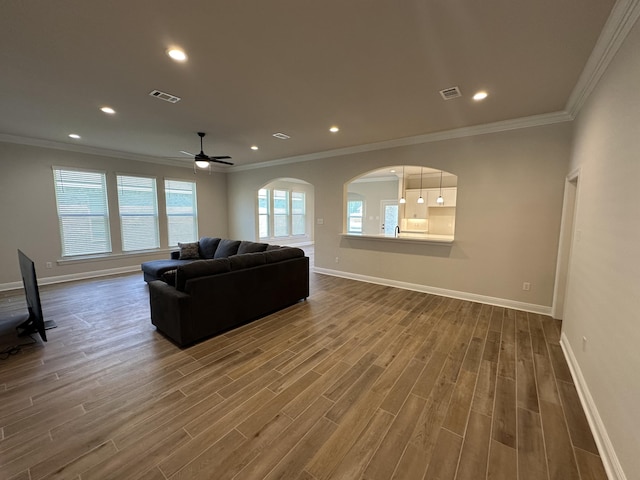 living room featuring hardwood / wood-style flooring, ceiling fan, and crown molding