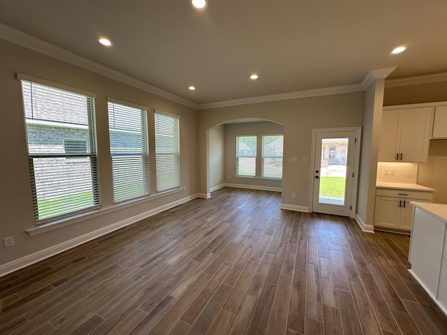 unfurnished living room featuring dark hardwood / wood-style floors and crown molding