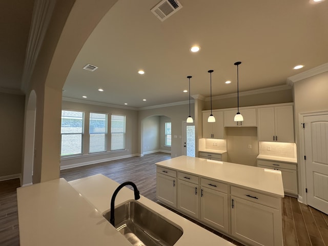 kitchen featuring a center island, decorative light fixtures, white cabinetry, and dark wood-type flooring