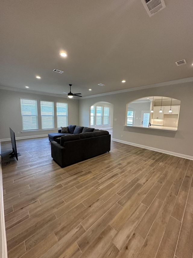 living room with ceiling fan, hardwood / wood-style floors, and ornamental molding