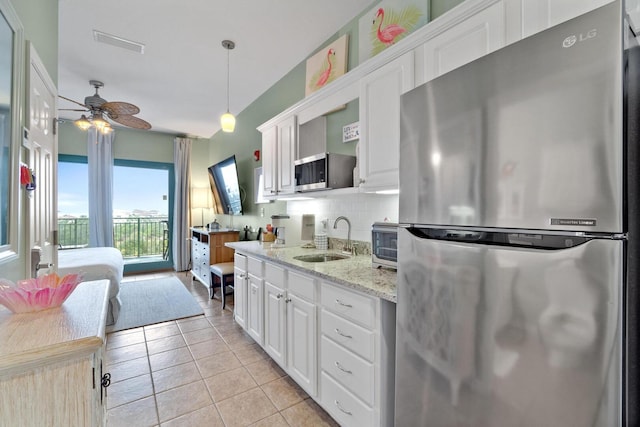 kitchen featuring ceiling fan, stainless steel appliances, backsplash, sink, and white cabinetry