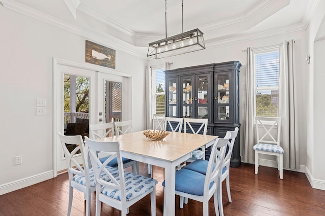 dining space featuring french doors, a tray ceiling, ornamental molding, and dark wood-type flooring