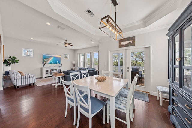 dining area featuring ceiling fan, french doors, a raised ceiling, dark hardwood / wood-style floors, and crown molding