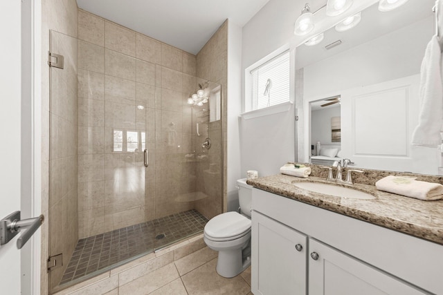 bathroom featuring vanity, tile patterned flooring, ceiling fan, toilet, and a shower with shower door