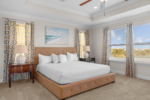 carpeted bedroom with a raised ceiling, ceiling fan, and crown molding