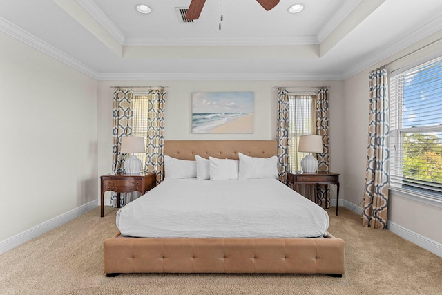 bedroom featuring a raised ceiling, ceiling fan, crown molding, and light colored carpet