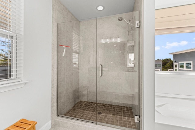 bathroom featuring plus walk in shower and a healthy amount of sunlight
