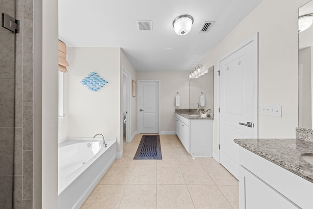 bathroom featuring tile patterned flooring, a bath, and vanity
