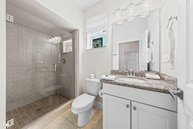 bathroom with an enclosed shower, vanity, toilet, and tile patterned floors