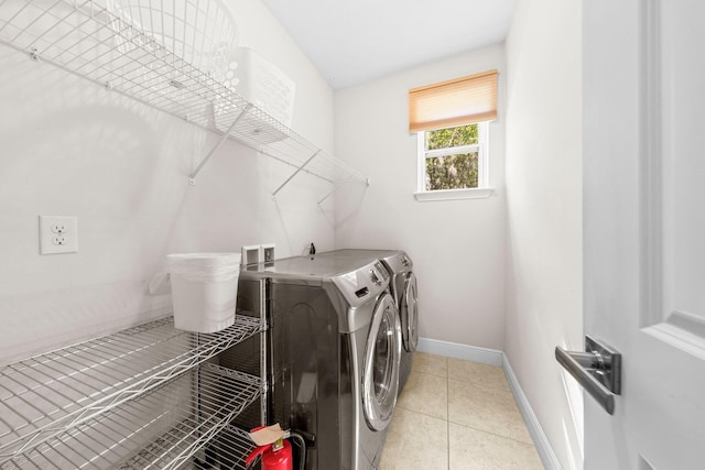 laundry area featuring washer and dryer and light tile patterned flooring