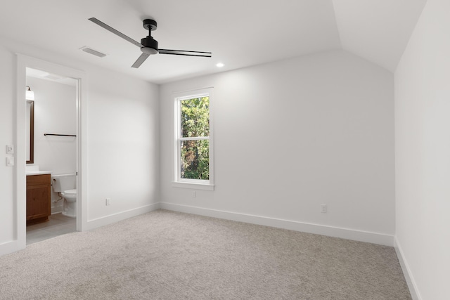 unfurnished bedroom with connected bathroom, ceiling fan, light colored carpet, and vaulted ceiling