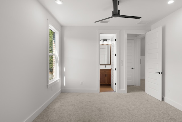 unfurnished bedroom featuring ensuite bath, ceiling fan, and light carpet