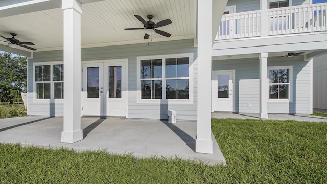 exterior space featuring a lawn, ceiling fan, a balcony, and french doors