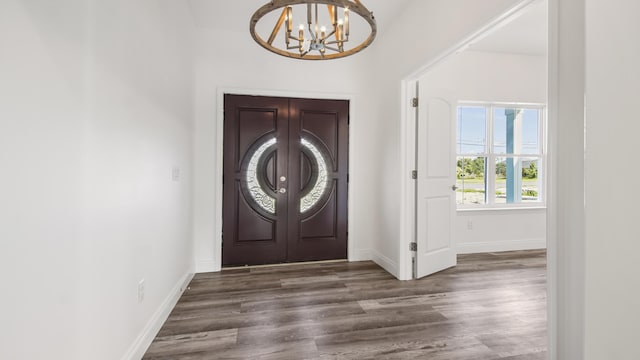 foyer entrance with dark hardwood / wood-style flooring and a notable chandelier