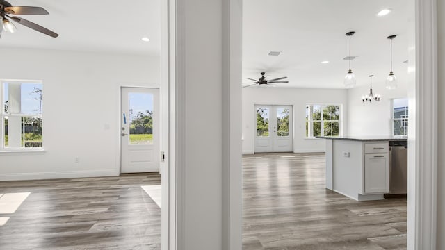 hall with french doors, light wood-type flooring, and an inviting chandelier