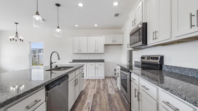 kitchen with pendant lighting, sink, white cabinetry, and stainless steel appliances