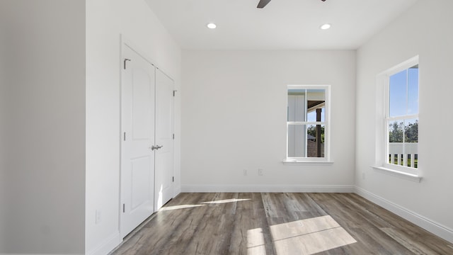 unfurnished bedroom with ceiling fan and dark wood-type flooring