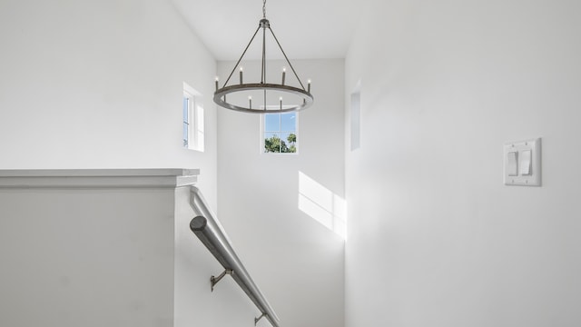 stairway featuring a high ceiling and an inviting chandelier