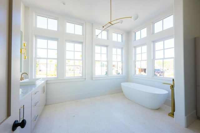 bathroom with a bathing tub, a wealth of natural light, and vanity