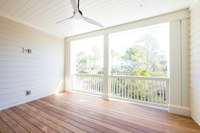 unfurnished sunroom with ceiling fan