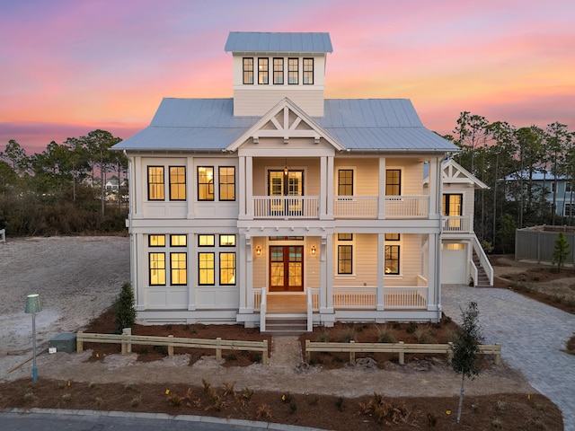 view of front of house featuring a balcony, covered porch, and french doors