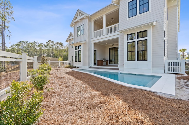 back of house with a fenced in pool, ceiling fan, and a patio area