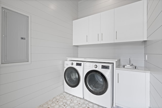 laundry area featuring cabinets, sink, electric panel, and washer and clothes dryer