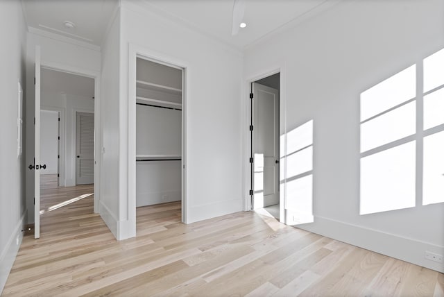 unfurnished bedroom featuring ornamental molding, light hardwood / wood-style floors, and a closet