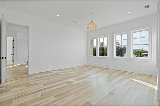 empty room with ornamental molding, light hardwood / wood-style floors, and a wealth of natural light