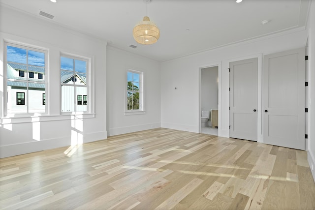 interior space with ornamental molding and light hardwood / wood-style floors