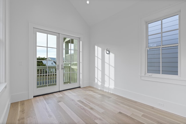 doorway to outside with lofted ceiling, light hardwood / wood-style floors, and french doors