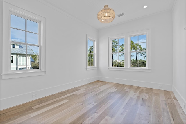 empty room featuring crown molding and light wood-type flooring