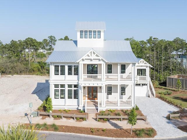 view of front of property with driveway, a balcony, and covered porch
