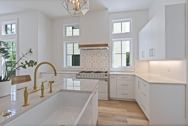 114 Climbing Rose Way, Santa Rosa Beach, FL 32459 - kitchen with high end white range, white cabinets, light wood-style floors, light stone countertops, and pendant lighting