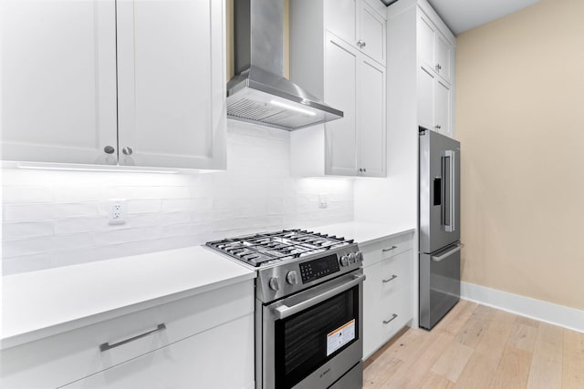 kitchen with light wood-type flooring, backsplash, high end appliances, wall chimney range hood, and white cabinets